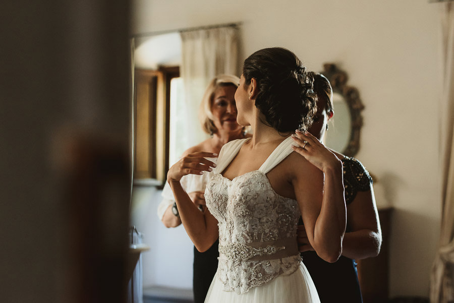 tuscany intimate wedding detail bride finishing to dress